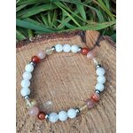 Bracelet PMA 6 mm posé sur rondin de bois avec feuillage vert, péristérite, pierre de soleil et cornaline pour courage doux, vitalité et stabilité émotionnelle