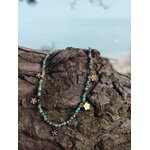 Collier doré vert africain facetté avec pendentifs fleur sur rocher en bord de mer, bijou acier inoxydable au style frais et lumineux
