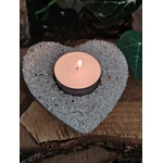 Bougeoir cœur en cristal de roche (quartz clair) avec bougie chauffe-plat allumée, posé sur rondin de bois et pierre sombre, ambiance douce, intention clarté et harmonie
