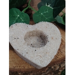 Bougeoir cœur en cristal de roche (quartz clair) posé sur rondin de bois, feuilles vertes en arrière-plan, cavité pour bougie chauffe-plat, déco naturelle, intention clarté et harmonie.