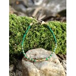 Bracelet malachite facettée 2 mm et cuivre plaqué or sur pierre claire devant mousse en forêt, ambiance nature et vert intense
