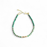 Bracelet fin en malachite facettée 2 mm sur fond blanc, cuivre plaqué or, forme ovale avec fermoir et vert profond lumineux.