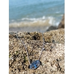 Collier argenté Arbre de Vie avec strass posé sur rochers de Bretagne face à la mer, ancrage doux et sérénité du cœur