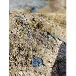 Pendentif Arbre de Vie argenté avec strass sur rochers à balanes en Bretagne, enracinement symbolique et paix intérieure