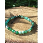 Bracelet Psoriasis 6 mm sur tranche de bois en plein soleil avec herbe en fond, pierres naturelles pour calme du cœur, équilibre et énergie plus douce