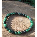 Bracelet rubis zoïsite posé sur galet gravé et support en bois au soleil, expression authentique, énergie du cœur et motivation intérieure