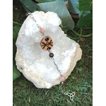 Bracelet rune de protection en bois création Magic Gaïa sur chaîne argentée, perles rose pâle et bordeaux, posé sur amas de quartz blanc avec feuilles vertes sur herbe; protection douce, ancrage, sérénité.