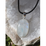 Pendentif labradorite blanche ovale sertie en argent 925 sur cordon noir, posé sur amas de quartz blanc en extérieur, pierre naturelle associée à l’intuition, à la douceur et à l’harmonie intérieure.