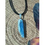 Pendentif cyanite bleue brute sur cordon noir, bélière argentée, posé sur bois et ailes de papillon; intention: clarté, sérénité.