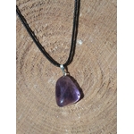 Pendentif en amétrine aux reflets violets sur cordon noir, présenté sur bois naturel, pierre naturelle évoquant l’inspiration, la tranquillité et la justesse intérieure.