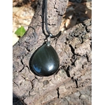 Pendentif obsidienne œil céleste en goutte sur cordon noir, posé sur écorce craquelée au soleil avec reflets profonds, bijou en pierre naturelle évoquant la stabilité, le recentrage et la puissance intérieure.