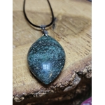 Pendentif en fuchsite avec inclusion de marcassite présenté sur vieux livre, dans une atmosphère douce et spirituelle évoquant harmonie, recentrage et sérénité.