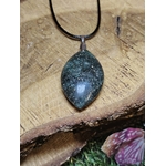 Pendentif en fuchsite avec inclusion de marcassite sur vieux grimoire, dans une ambiance ésotérique, évoquant clarté, harmonie et apaisement.