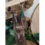 Boucles d’oreilles fée création Magic Gaïa suspendues à une écorce, ailes translucides vertes, chaînettes argentées et perles claires, sur fond doux naturel, pour une touche poétique, légère et féerique.