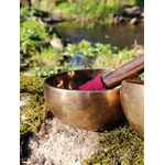 Bol tibétain doré sur rocher moussu en Bretagne, près d’un ruisseau, maillet au feutre rouge, pour inviter au calme, à l’ancrage et à la clarté.