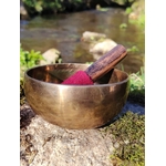 Bol tibétain doré posé sur un rocher moussu en Bretagne, au bord d’un ruisseau, maillet en bois au feutre rouge, pour apaiser, s’ancrer et clarifier l’esprit.