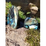 Deux labradorites forme libre aux reflets bleus posées sur rocher et mousse en Bretagne près d’un ruisseau, pierres naturelles évoquant le recentrage, la paix du mental et la sensibilité intuitive.