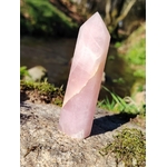 Pointe de quartz rose facettée dressée sur granit et mousse en Bretagne, près d’un ruisseau, pour apaiser le cœur, adoucir les émotions et encourager l’amour de soi.