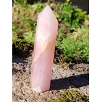 Pointe de quartz rose facettée posée sur rocher et mousse en pleine nature, pour inviter à la douceur, apaiser le cœur et encourager l’amour de soi