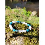 Bracelet TDAH création Magic Gaïa en apatite et sélénite sur rocher moussu en Bretagne, perles bleues et blanches pour canaliser l’agitation et retrouver un axe plus stable