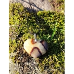 Pendentif cœur en septaria posé sur une souche en forêt bretonne, entouré de verdure et baigné de lumière naturelle, pierre naturelle associée à l’ancrage, à la force douce et à l’équilibre intérieur.