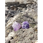 Deux améthystes brutes violettes posées sur un rocher granitique en Bretagne, mer et galets en arrière-plan, pour inviter au calme, à la protection et à la clarté.