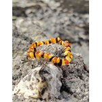 Bracelet enfant en ambre baroque sur décor minéral breton, perles naturelles miel et cognac, douceur rassurante et calme intérieur