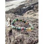 Bracelet Agate Indienne 6 mm sur rocher granitique face à la mer en Bretagne, perles vertes et beige marbrées, sérénité et tenue émotionnelle