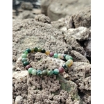 Bracelet agate indienne 6 mm en cercle sur rochers bretons, perles vert d’eau et tons terre au milieu des galets, pour apaiser, ancrer et harmoniser.