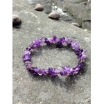 Bracelet baroque en améthyste posé sur sable et galets au bord de l’océan, bijou violet favorisant détente et inspiration