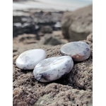Galets de calcédoine dendritique posés sur les rochers en Bretagne face à la mer, pierres naturelles évoquant l’enracinement, la tranquillité et la lucidité intérieure.