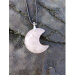 Pendentif lune en quartz rose naturel sur fond de roche sombre, photo Bretagne, collier délicat évoquant la sensibilité, le calme émotionnel et l’harmonie du cœur.