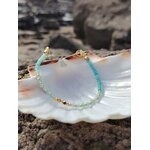 Bracelet amazonite facettée 2 mm sur coquillage blanc en Bretagne, fond rocheux flou et reflets bleu turquoise, élégance et apaisement