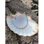 Bracelet fin en amazonite facettée et cuivre plaqué or sur coquillage blanc, photo Bretagne sur roche sombre, harmonie et sérénité