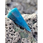 Pendule en apatite bleue posé sur un rocher couvert de balanes, en décor côtier breton aux tons minéraux, photo prise en Bretagne, évoquant intuition, apaisement émotionnel et clarté intérieure.