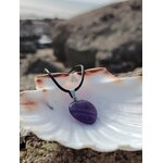 Pendentif améthyste sur cordon noir présenté sur un coquillage face à la mer, sérénité mentale et écoute intérieure