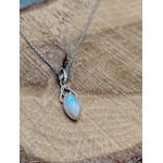 Pendentif elfique en péristérite argent 925 avec chaîne en acier inoxydable, posé sur bois naturel aux veines marquées, reflet bleu irisé, décor chaleureux évoquant intuition, calme et douceur.