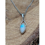 Pendentif elfique en péristérite argent 925 avec chaîne en acier inoxydable, présenté sur bois naturel aux teintes chaudes, reflet bleu lumineux, décor sobre évoquant intuition, sérénité et douceur.