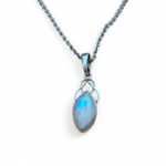 Pendentif elfique en péristérite argent 925 avec chaîne en acier inoxydable, présenté sur fond clair épuré, reflets bleu irisé au centre, ambiance sobre évoquant intuition, douceur et apaisement.