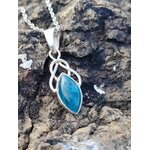Pendentif elfique en apatite bleue et argent 925 posé sur un rocher breton aux teintes minérales, bijou en pierre naturelle associé à l’inspiration, à la parole fluide et au calme intérieur.