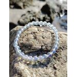 Bracelet Angel Aura aux perles irisées sur rochers en ambiance marine lumineuse, création apaisante en cristal de roche 6 mm.
