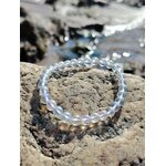Bracelet Angel Aura Quartz 6 mm face à la mer sur rochers bretons, reflets irisés bleutés, intuition et sérénité