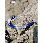 Bracelet migraine en lapis-lazuli, labradorite et sélénite 6 mm, posé entre les rochers bretons dans une ambiance naturelle de douceur, d’apaisement et d’harmonie intérieure.