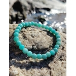 Bracelet amazonite 6 mm sur rochers bretons au bord de l’eau, perles bleu-vert en pierre naturelle, apaisement émotionnel et communication fluide