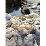 Bracelet semainier Love en quartz rose et acier inoxydable sur rochers en Bretagne près de l’eau, bijou romantique aux nuances rose poudré