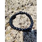 Bracelet shungite 6 mm en cercle sur écorce beige veinée, photo Bretagne, recul mental, ancrage net et endurance émotionnelle
