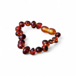 Bracelet ambre bébé sur fond blanc, perles naturelles aux teintes miel et cognac, fermoir sécurisé, bijou enfant sobre et élégant