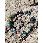 Bracelet chakra cœur photographié sur les rochers bretons, agate mousse et tourmaline melon d’eau pour ouverture émotionnelle, écoute de soi et harmonie intérieure
