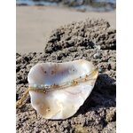 Bracelet doré multi-rang en amazonite facettée sur roche et coquillage en Bretagne, détail lumineux des chaînes et perles bleues