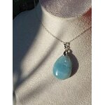 Pendentif en aigue-marine porté au cou sur chaîne argentée, bijou en pierre naturelle évoquant la douceur relationnelle, l’expression sincère et l’harmonie intérieure.